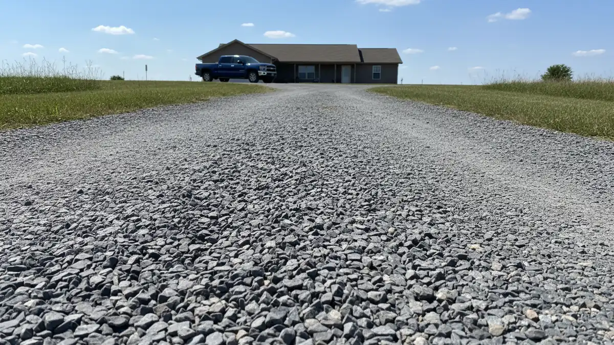 Crushed stone gravel driveway leading to a rural residential home